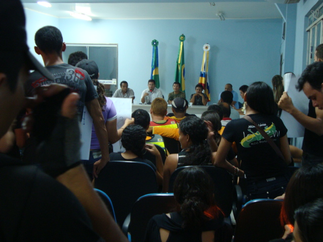 Universitários e professores em greve invadem câmara de vereadores com faixas e velas acesas.